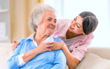 elderly patient smiling to her caregiver