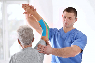 caregiver and elderly man doing physical therapy